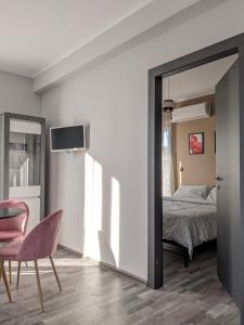 a bedroom with a mirror and a chair and a bed at Bardolino Center Apartments in Bardolino