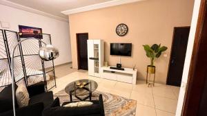 a living room with a couch and a tv at Large studio at your disposal in Abidjan in Cocody