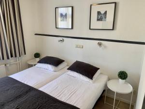 duas camas num quarto com duas mesas em Hotel de la Bourse em Maastricht