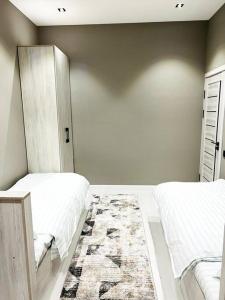 um quarto com 2 camas e um tapete em 3-roomed apartment close to the REGISTAN Ozod Apartments em Samarcanda