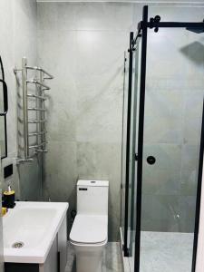 y baño con aseo, lavabo y ducha. en 3-roomed apartment close to the REGISTAN Ozod Apartments en Samarcanda