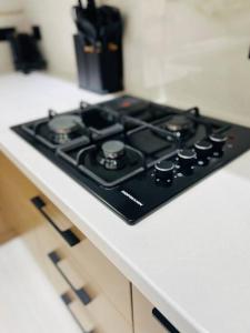 - une cuisinière noire sur un comptoir dans la cuisine dans l'établissement 3-roomed apartment close to the REGISTAN Ozod Apartments, à Samarcande