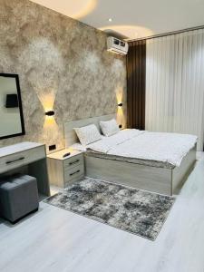 a bedroom with a bed and a desk and a television at 3-roomed apartment close to the REGISTAN Ozod Apartments in Samarkand +8 photos
