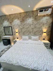 a bedroom with a large white bed and a television at 3-roomed apartment close to the REGISTAN Ozod Apartments in Samarkand