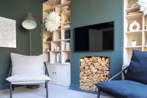 ein Wohnzimmer mit einem Kamin und einem TV darüber. in der Unterkunft Beautiful Oxford Townhouse near City Centre in Oxford