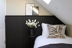 eine Vase mit weißen Blumen im Schlafzimmer in der Unterkunft Beautiful Oxford Townhouse near City Centre in Oxford