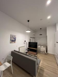 Moratalaz Apartments في مدريد: غرفة معيشة مع أريكة وبيانو