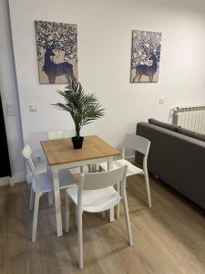 sala de estar con mesa, sillas y sofá en Moratalaz Apartments, en Madrid