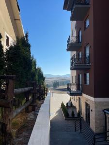 un edificio con una valla al lado de una calle en Apartman GreenLo, en Zlatibor