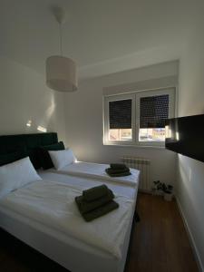 Un dormitorio con una cama blanca con dos toallas encima. en Apartman GreenLo, en Zlatibor