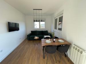 sala de estar con mesa y sofá verde en Apartman GreenLo, en Zlatibor