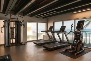 a gym with two treadmills and two exercise bikes at The Hillsboro powered by Sonder in Deerfield Beach