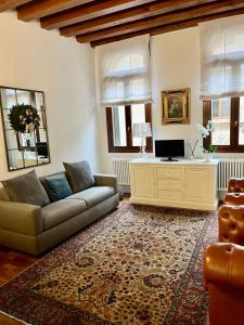 a living room with a couch and a tv at SANTA CATERINA: charming apartment TREVISO in Treviso