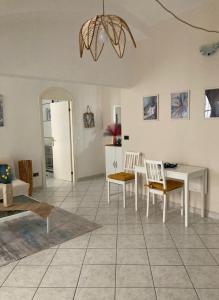 ein Wohnzimmer mit einem weißen Tisch und Stühlen in der Unterkunft CASA PALOMA in Sanremo
