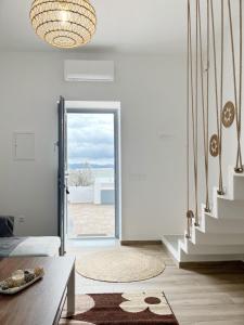 a living room with a staircase and a glass door at Sorokos House in Prodromos Paros