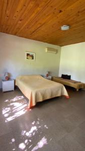 1 dormitorio con 1 cama grande y techo de madera en El Lirio Blan - Alquiler temporario en Capilla del Monte