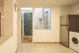 a kitchen with a refrigerator and a washer and dryer at Casa Calera. Con terraza y bbq in Santa Pola
