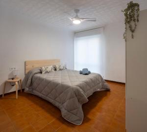 1 dormitorio con 1 cama y ventilador de techo en Casa Calera. Con terraza y bbq, en Santa Pola