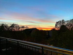 a sunset over a road with a fence and trees at Luxury Penthouse Jacuzzi, Pool Table, Bbq & Desks in Berlin