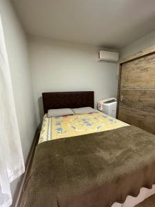 um pequeno quarto com uma cama num quarto em Residencial Marina em Florianópolis