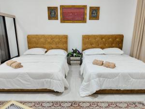 淡馬魯的住宿－Homestay Temerloh Nasuha Homestay For Muslim Near Hospital with Private Pool Wi-Fi Netflix，卧室内的两张床,配有白色床单和枕头