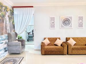 a living room with a couch and a chair at Homestay Temerloh Nasuha Homestay For Muslim Near Hospital with Private Pool Wi-Fi Netflix in Temerloh