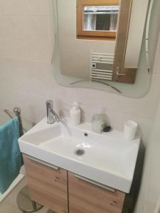 W łazience znajduje się biała umywalka i lustro. w obiekcie House for rest and fun JEKA w mieście Duga Resa