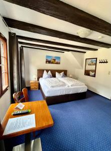 ein Hotelzimmer mit einem Bett und einem Tisch in der Unterkunft Gästehaus AM HAFEN in Meersburg