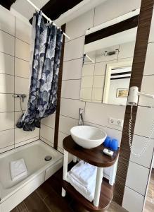 a bathroom with a sink and a tub at Gästehaus AM HAFEN in Meersburg