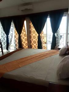 sypialnia z łóżkiem z niebieskimi zasłonami w obiekcie Annexe RAOOF HOTEL w mieście Mahajanga