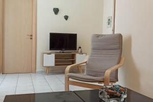 a living room with a chair and a television at Arta House in Arta