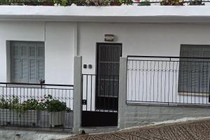 a white house with a black door and windows at Arta House in Arta
