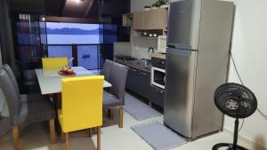 a kitchen with a dining table and a refrigerator at Marques Home in Porto Belo