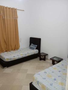a room with two beds and a laptop on a couch at إقامة النسرين in Yasmine