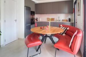 cocina con mesa de madera y 2 sillas rojas en Taste Tavira (by Annick) fully equipped apartment, tastefully decorated, perfect location and free parkingric center of the city of Tavira., en Tavira