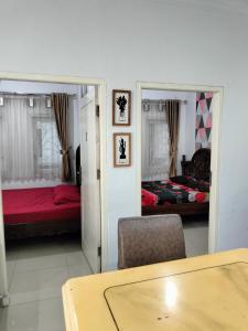 a room with two beds and a table and chairs at VILLA KID HOUSE BOGOR in Gununggeulis