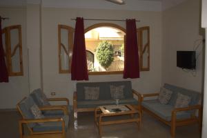 un soggiorno con divano, 2 sedie e tavolo di Morning Start Apartments a Luxor