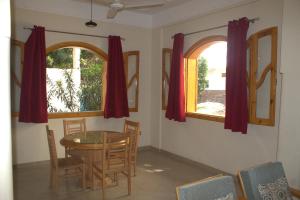 una sala da pranzo con tavolo e 2 finestre di Morning Start Apartments a Luxor