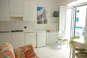 een keuken met witte kasten en een bank in een kamer bij Al Molo in Rio Marina