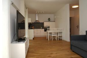 een keuken en een woonkamer met een tafel en stoelen bij Voßgarten Wohnung 1 in Duhnen