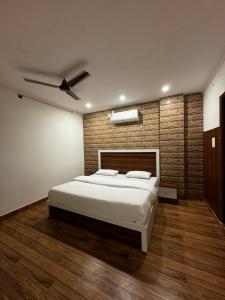 a bedroom with a bed and a brick wall at Hotel Walk Inn in Faridabad