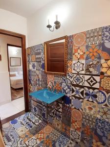 La salle de bains est pourvue d'un lavabo et de mosaïques. dans l'établissement Rincón de Paz Apart & Loft Suite Boutique - Adults Only, à Villa Carlos Paz