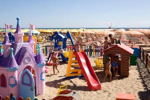 a group of children playing in a playground on the beach at Hotel Bella Romagna in Rimini