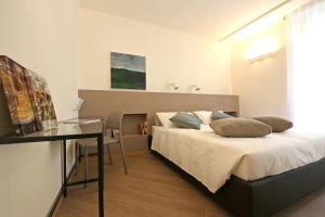 1 dormitorio con cama y escritorio. en Residence Matilde, en Oliveto Lario