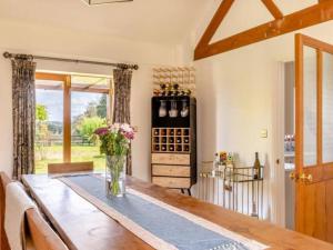 a kitchen with a table with a vase of flowers at The Stables 