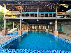 una gran piscina con una terraza sobre ella en Cozy Paradise, en Battambang