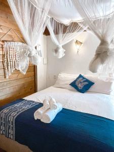 a bedroom with a bed with towels on it at Atins Beach Houses in Atins