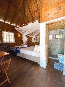 a bedroom with a bed with a mosquito net at Atins Beach Houses in Atins