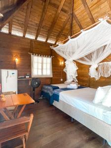 a bedroom with two beds and a desk and a table at Atins Beach Houses in Atins