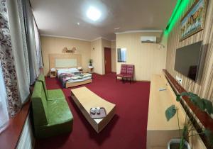 アルマトイにあるZolotoi Drakon Hotelのベッドとソファ付きのホテルルーム